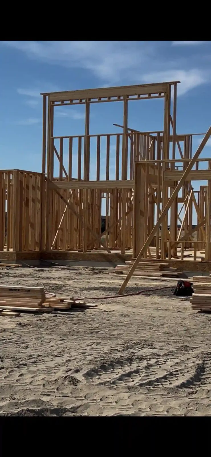 J&M Construction and Cleaning jobsite sign on an active framing project