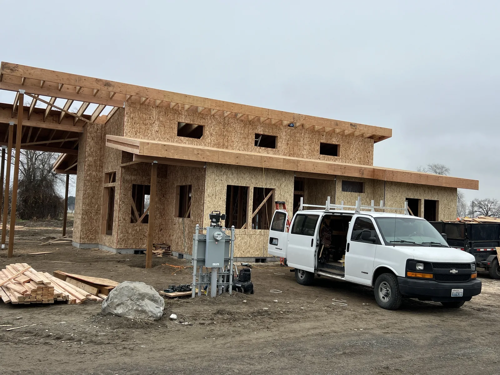 Framed single-story custom home exterior with layered shed roofs and covered entry